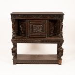 A Charles I oak livery cupboard, circa 1640, twin carved serpent motifs to the central door,