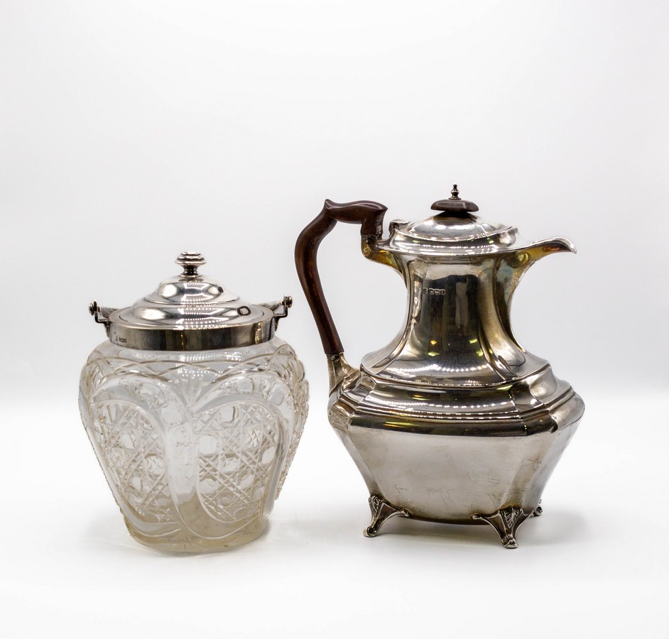 An Edwardian cut glass biscuit barrel with silver mounts, Sheffield 1905 and a silver hot water jug,