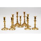 A set of four 18th Century brass candlesticks and five others,