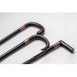 An ebony spiral walking stick with silver mount and two others,