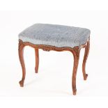 An upholstered footstool on cabriole legs,