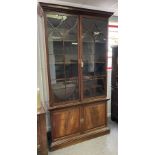 A mahogany bookcase enclosed by glazed doors with cupboard beneath, 235cm high x 127.