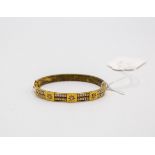 A Victorian gilt metal christening bangle, set with three old cut diamonds with two rows of pearls,