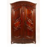 A Continental walnut armoire enclosed by panel doors,