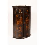 An early 19th Century bowfront corner cupboard in black and gold lacquer CONDITION