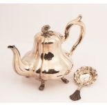 A Danish silver teapot, of melon-shape with flower finial, on four paw feet,