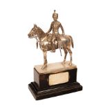 A silver figure of a Royal Gloucestershire Hussar on a rectangular stained plinth base,
