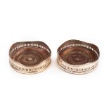 A pair of George III silver wine coasters, London 1801 and 1806, with wavy rims,