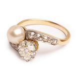 An early 20th Century diamond and pearl 'toi et moi' ring, the old cut diamond approximately 6.