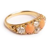 A Victorian diamond and coral ring set with four old cut diamonds and two oval cabochon corals,