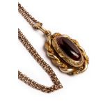 A Victorian gilt metal and garnet set oval locket pendant,