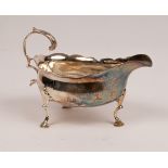 A George III silver sauce boat, Walter Brind, London 1771, with wavy rim and scroll handle,