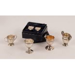 Three miniature silver trophy cups, an egg cup and a pair of cased napkin rings,