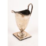 A Victorian helmet-shaped silver cream jug, Nathan & Hayes, Birmingham 1892, on with a square base,