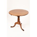 A George III style oak tripod table, the circular tilt top above a baluster turned column,