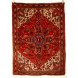 A Heriz rug, North West Persia, the madder field centred by an indigo medallion,