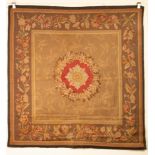 An Aubusson style Tapestry, the soft brown field centred by a circular floral wreath rose medallion,