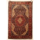 A Sarouk rug, West Persia, the indigo field of Herati design centred by a madder pendant medallion,