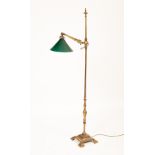A brass floor standing reading light, with green glass shade,