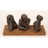Three bronze busts, studies of a pensive man, on a rectangular oak plinth, 37cm wide,