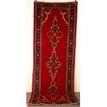 A Hamadan runner, West Persia, the burgundy field with indigo medallions,