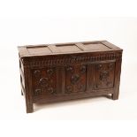 A late 17th Century oak and inlaid coffer, the triple panel hinged lid above a fluted carved frieze,