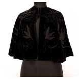 A Victorian black velvet cape with applied beadwork decoration of stylised leaves and swags,