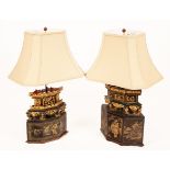 Two Chinese carved and lacquered lamp bases with cream shaped shades,