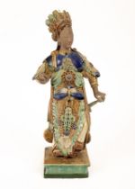 A Chinese Shiwan pottery figure of a lady, Qing dynasty, standing holding sword hilt, 55.