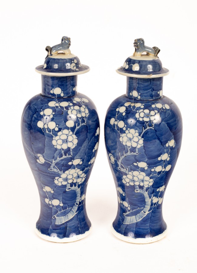 A pair of 20th Century Chinese blue and white bulbous vases and covers, decorated prunus,