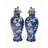 A pair of 20th Century Chinese blue and white bulbous vases and covers, decorated prunus,