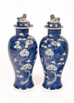 A pair of 20th Century Chinese blue and white bulbous vases and covers, decorated prunus,