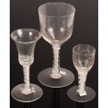 An English 18th Century wine glass with a bell bowl and solid base on a stem with two white spirals,