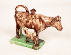 An English creamware Whieldon type cow and calf creamer, sponged in brown, circa 1760, bears D.M.