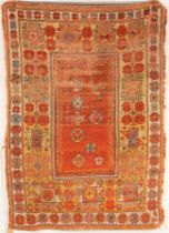 A Melas rug, West Anatolia, circa 1870, the plain madder field with scattered stellar motifs,