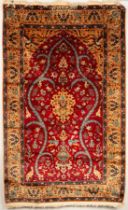 A Turkish prayer rug, the strawberry red field of birds and animals centred by a peach medallion,