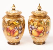 A near pair of Royal Worcester pot-pourri vases and covers, painted with peaches, cherries.