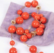 A yellow metal and coral bead necklace