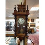 A Vienna eight-day wall clock in a walnut case flanked by pilasters,