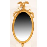 A Regency giltwood mirror, the eagle crest holding a chair with two balls,