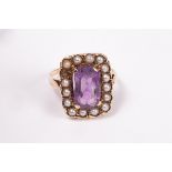 An amethyst and seed pearl ring, the central amethyst approximately 10mm x 7mm,