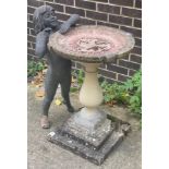 A reconstituted stone bird bath on a pedestal column and square base,