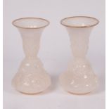A pair of French white opaline glass vases, circa 1850, moulded with flowering tendrils,
