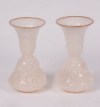 A pair of French white opaline glass vases, circa 1850, moulded with flowering tendrils,