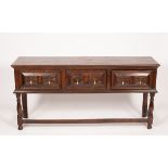 An oak dresser of 17th Century design, fitted three drawers with geometric fronts,