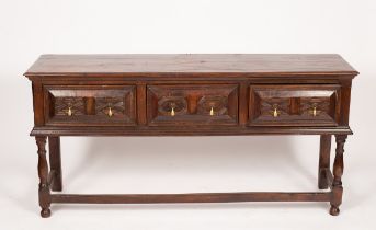 An oak dresser of 17th Century design, fitted three drawers with geometric fronts,