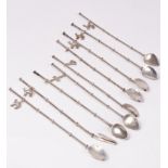 Nine sterling silver iced tea spoons/straws, 20th Century, seven hung with small charms, 21.