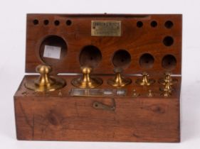 A mahogany case of thirteen brass cylinder weights,
