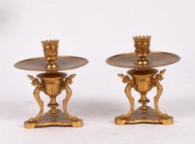 A pair of Regency style gilt metal candlesticks, 19th Century, with sphinx trefoil bases,
