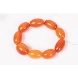 An orange agate bead bracelet of nine oval beads, a gold opal and diamond stick pin,